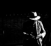 A silhouette of a suited figure in a fedora hat against a dark cityscape, blending mafia style with modern intrigue.