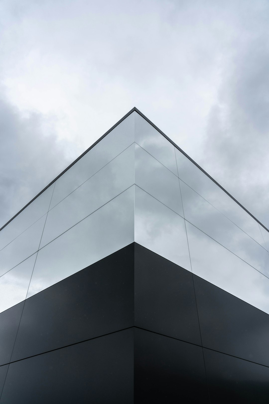 low angle photography of gray concrete building under white clouds during daytime