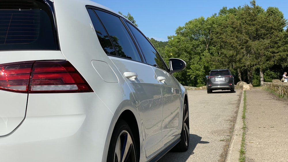 white sedan on gray asphalt road during daytime