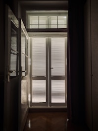 A skilled technician measuring a window in a bright living room for custom blinds installation.