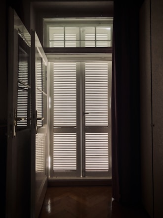 A skilled technician measuring a window in a bright living room for custom blinds installation.