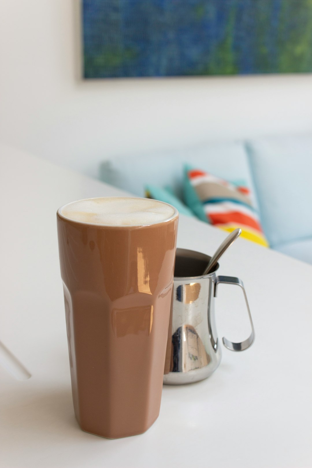 brown and white ceramic mug on white table