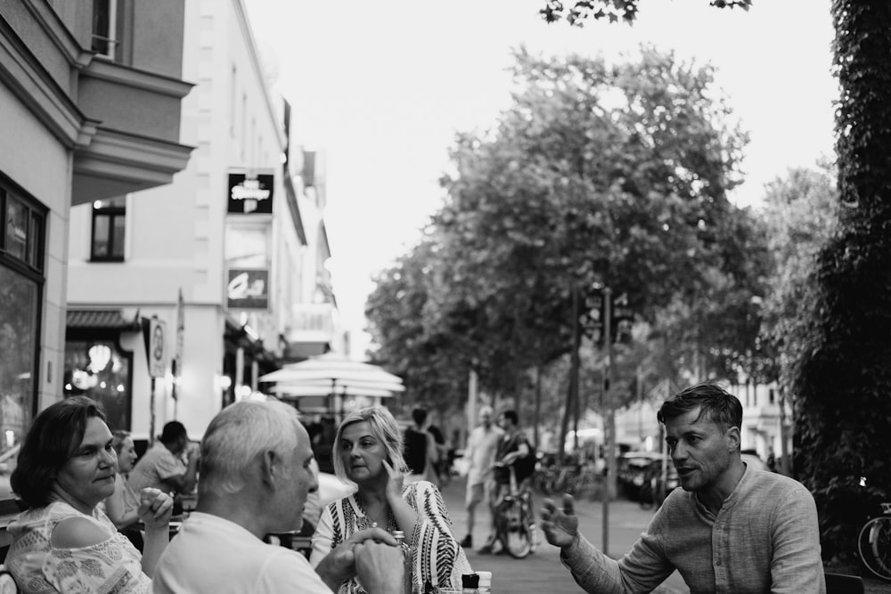 Graustufenfoto von Menschen, die auf der Straße spazieren gehen