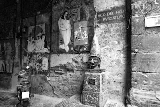 grayscale photo of man in hat and sunglasses on wall