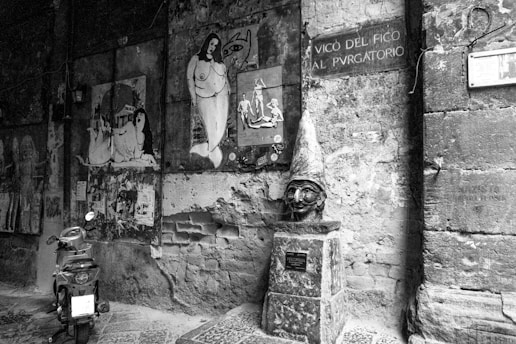 grayscale photo of man in hat and sunglasses on wall