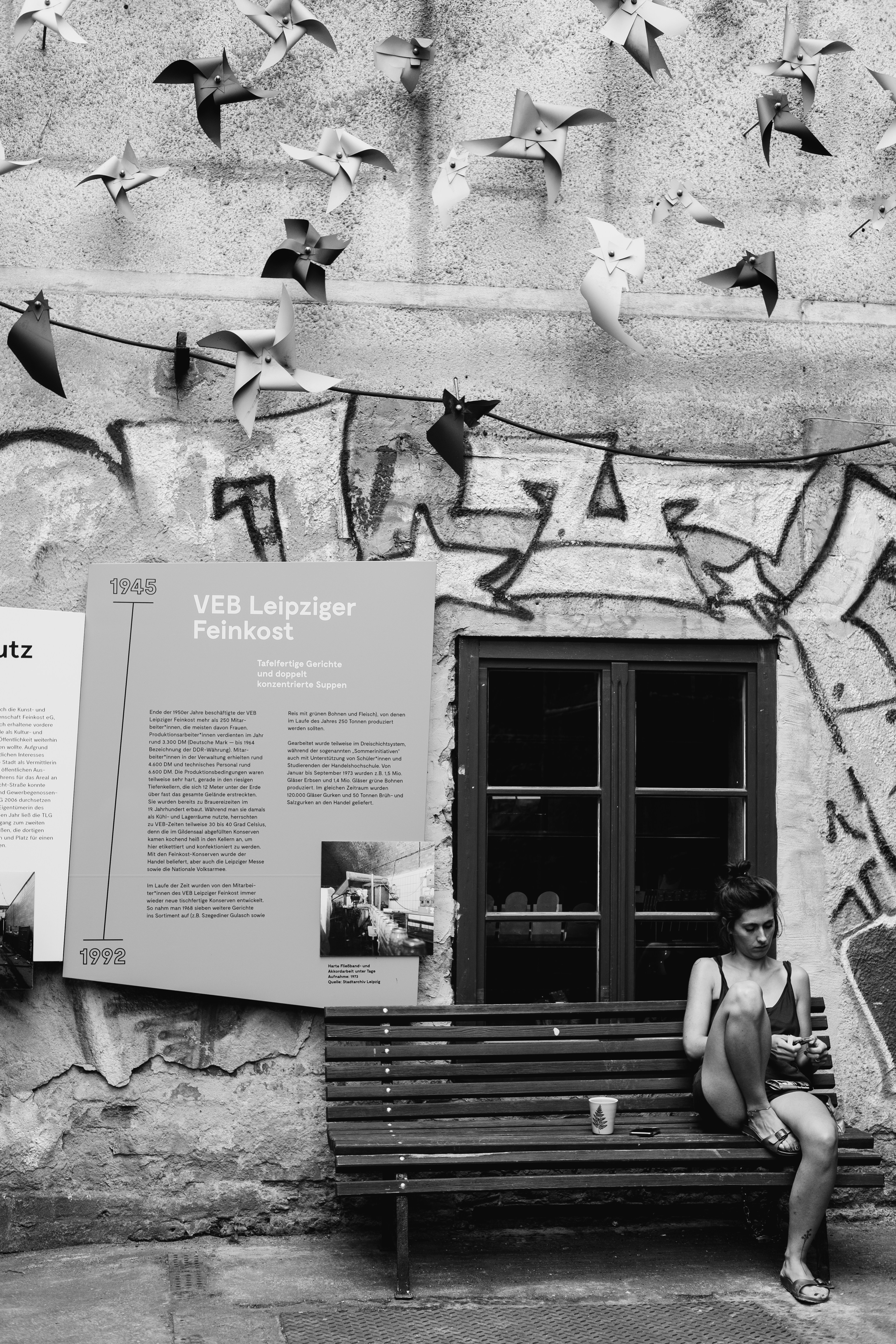 grayscale photo of men and women sitting on bench