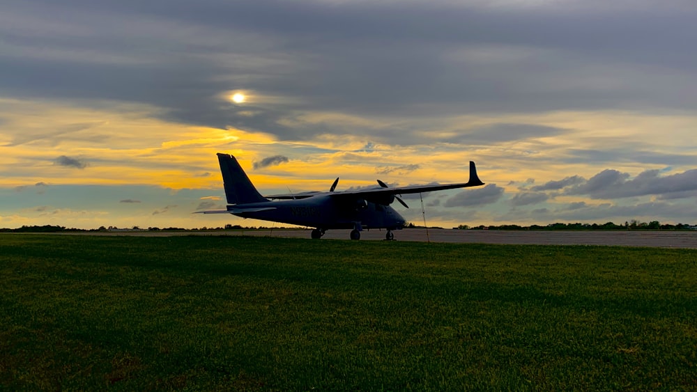 black jet plane on green grass field under cloudy sky during daytime