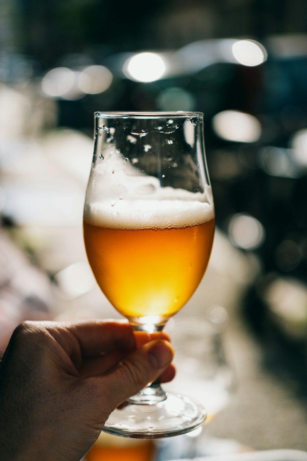 person holding clear drinking glass with beer