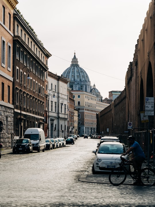 cars parked on side of road near brown concrete building during daytime in Saint Peter's Square Italy