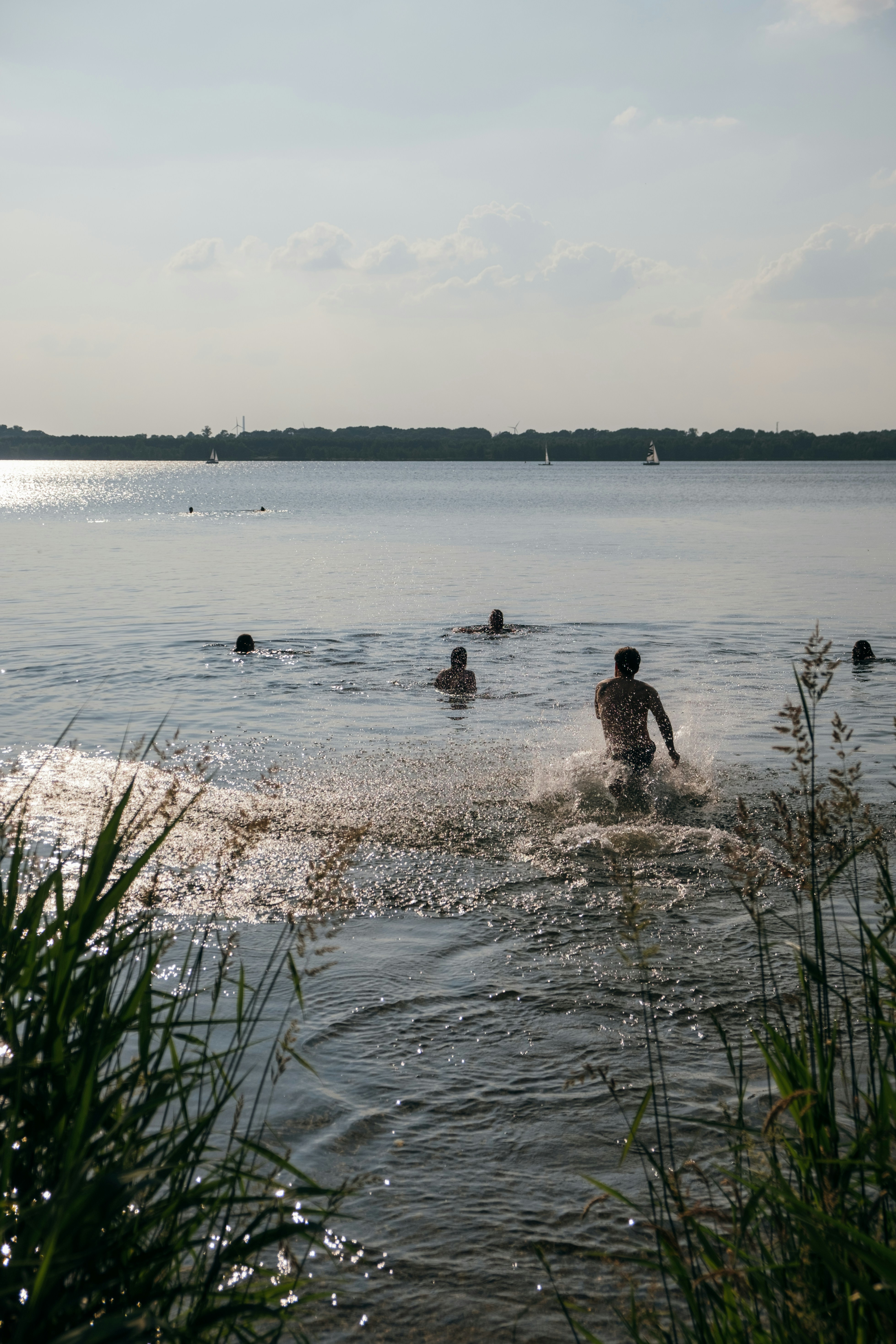 Friends jumping into a cold lake on a hot summer day