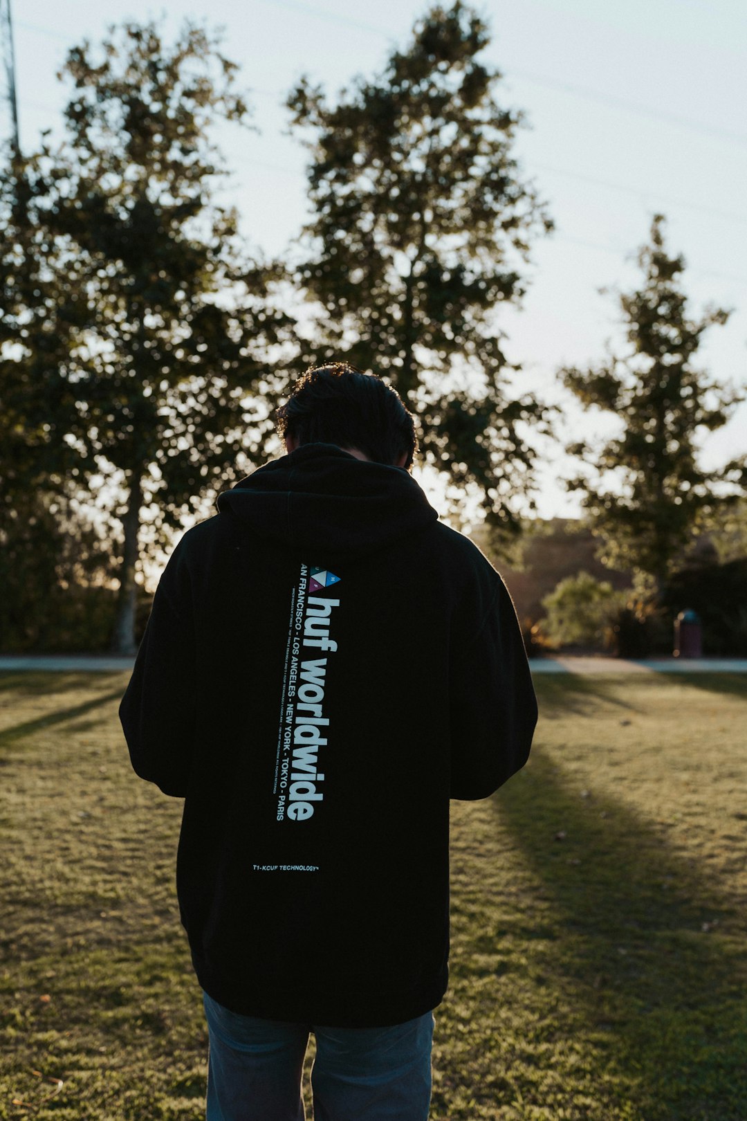 man in black hoodie standing on road during daytime