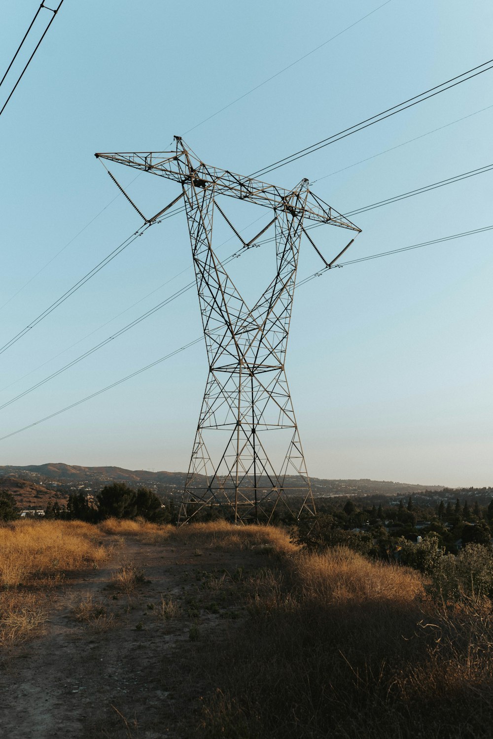 black electric tower on brown grass field during daytime