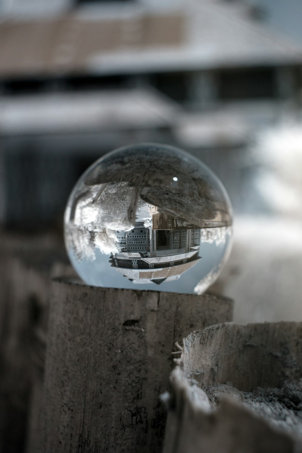 clear glass ball on brown wooden fence