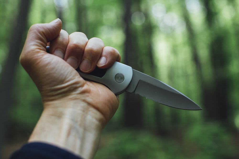 person holding gray and black knife