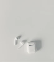 A stylish pair of wireless earbuds resting on a minimalist white surface.