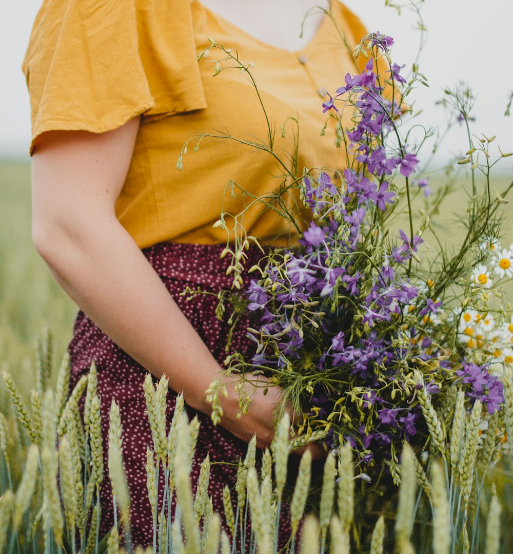 woman in yellow shirt standing on purple flower field during daytime