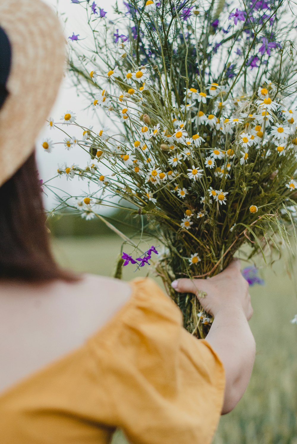 person holding white and yellow flowers