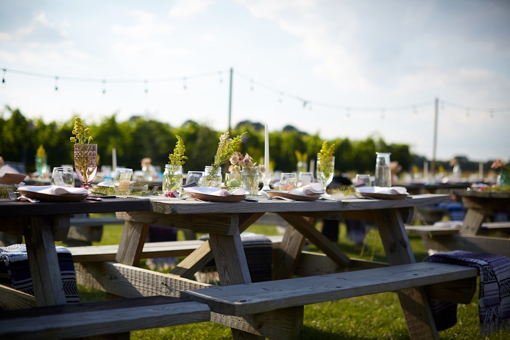 brown wooden table with chairs on green grass field during daytime