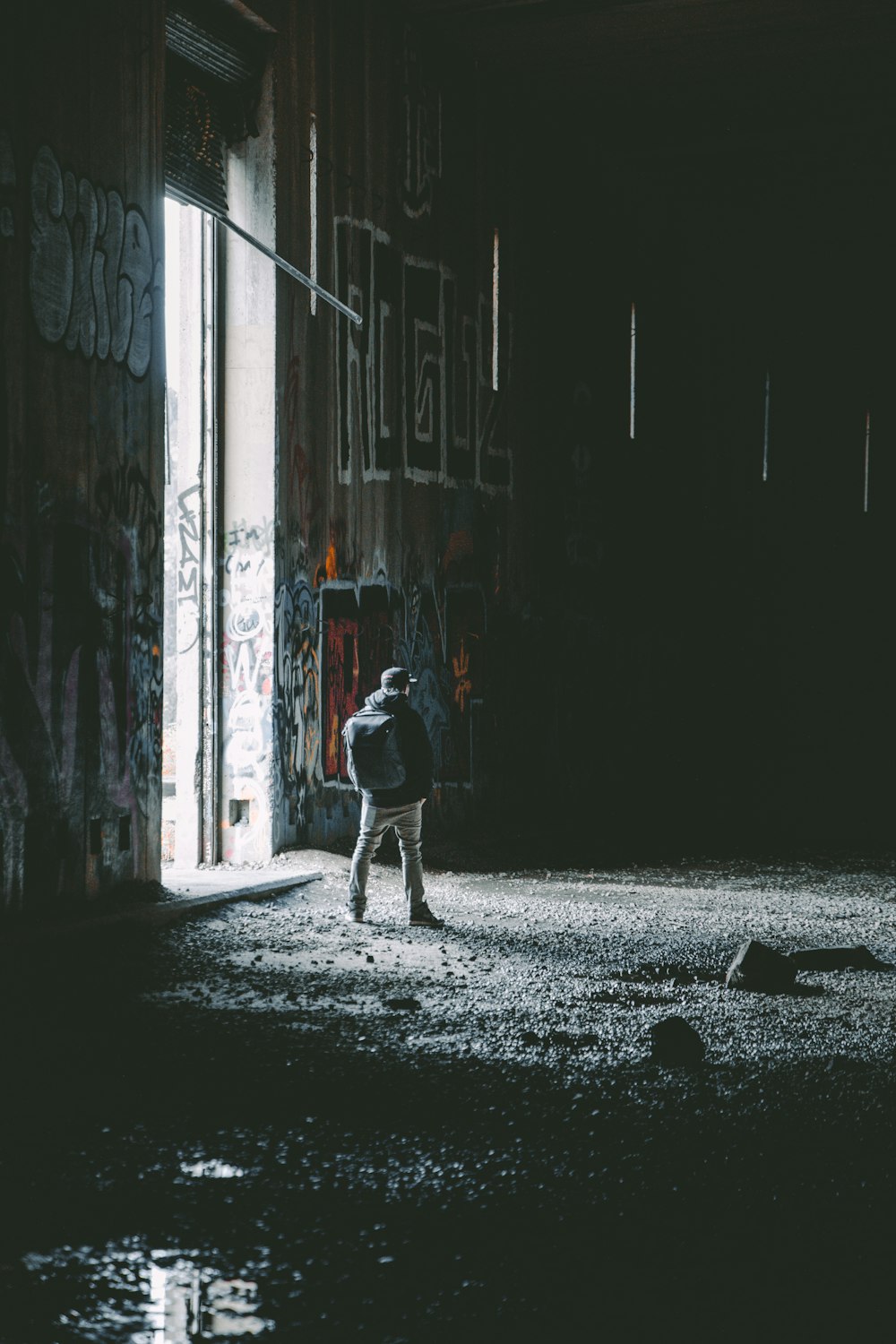 man in black jacket walking on hallway