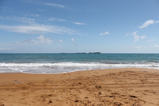 brown sand beach under blue sky during daytime in Xi Beach Greece