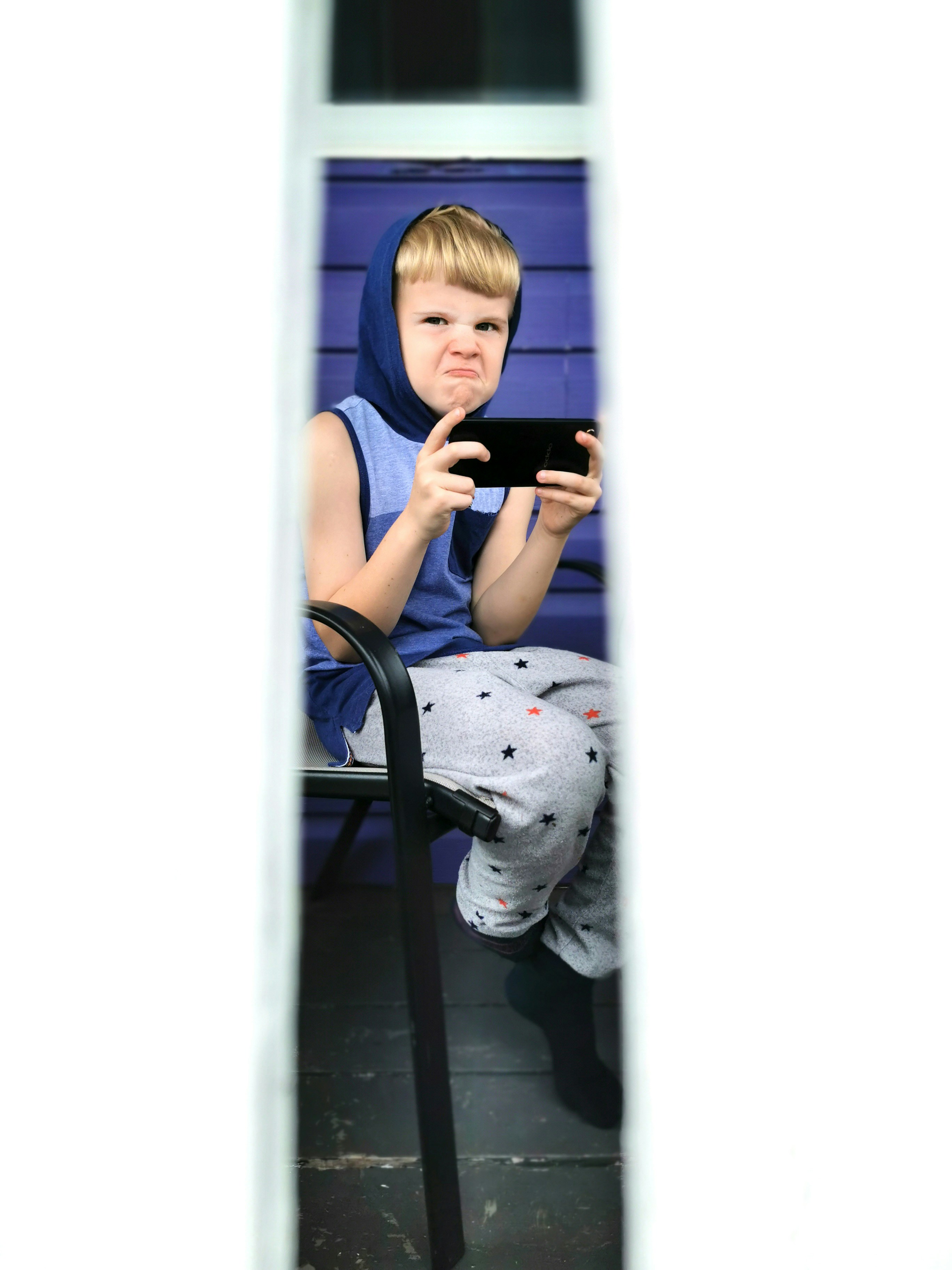 boy in blue tank top sitting on chair