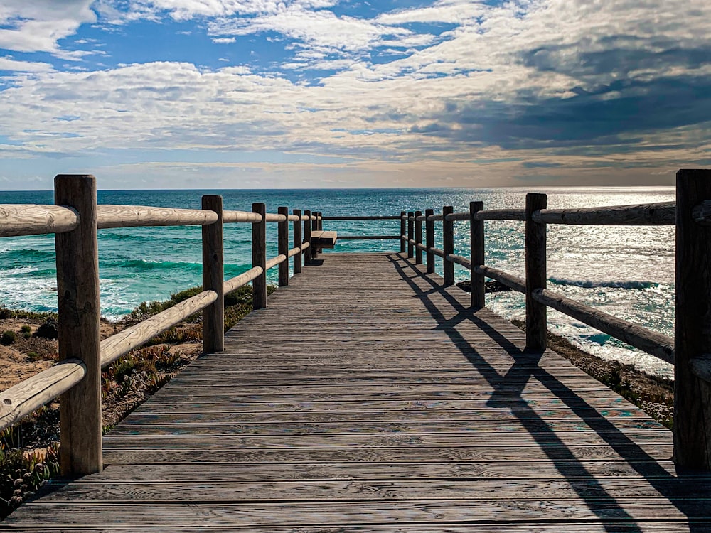 muelle de madera marrón en el mar bajo el cielo azul y las nubes blancas durante el día