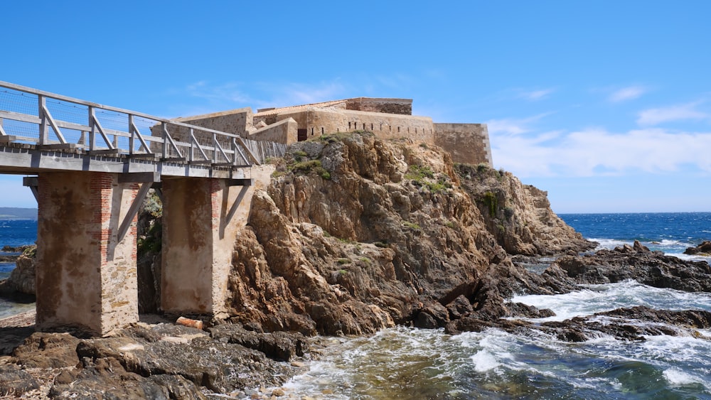 brown concrete building on rocky shore during daytime