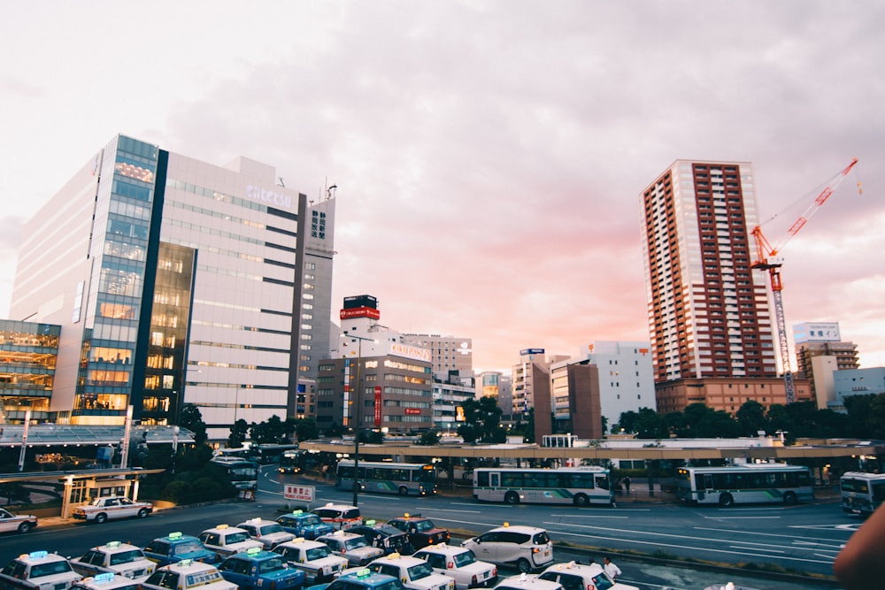 cars parked on parking lot near high rise buildings during daytime