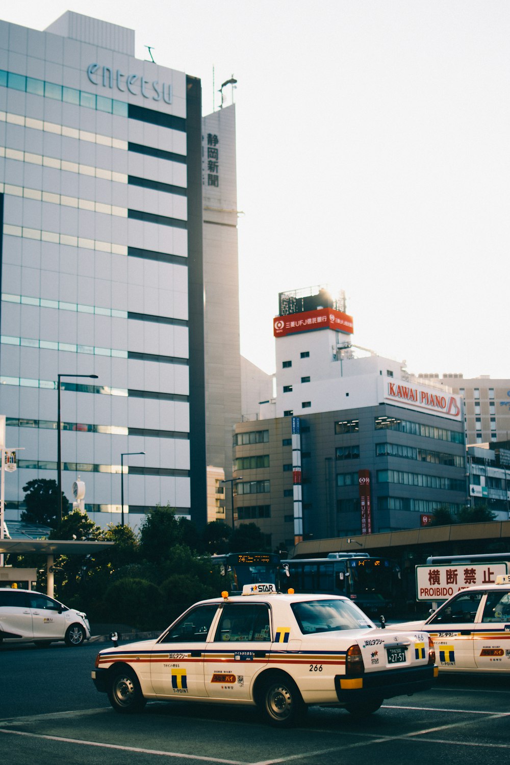 cars parked on side of the road near high rise buildings during daytime