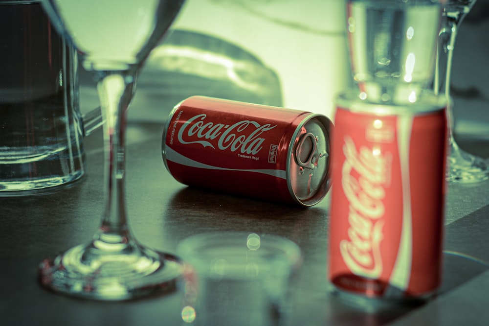 coca cola can beside clear wine glass
