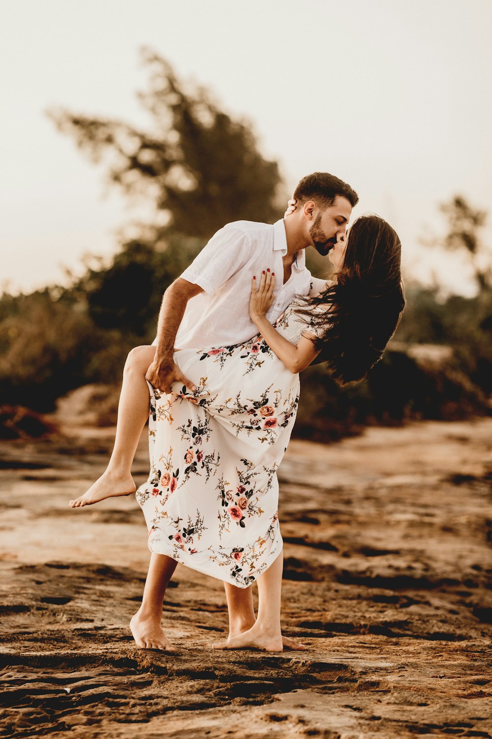 man and woman kissing on beach during daytime