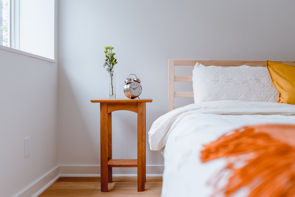 brown wooden table with white and orange floral bed linen