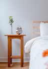 brown wooden table with white and orange floral bed linen