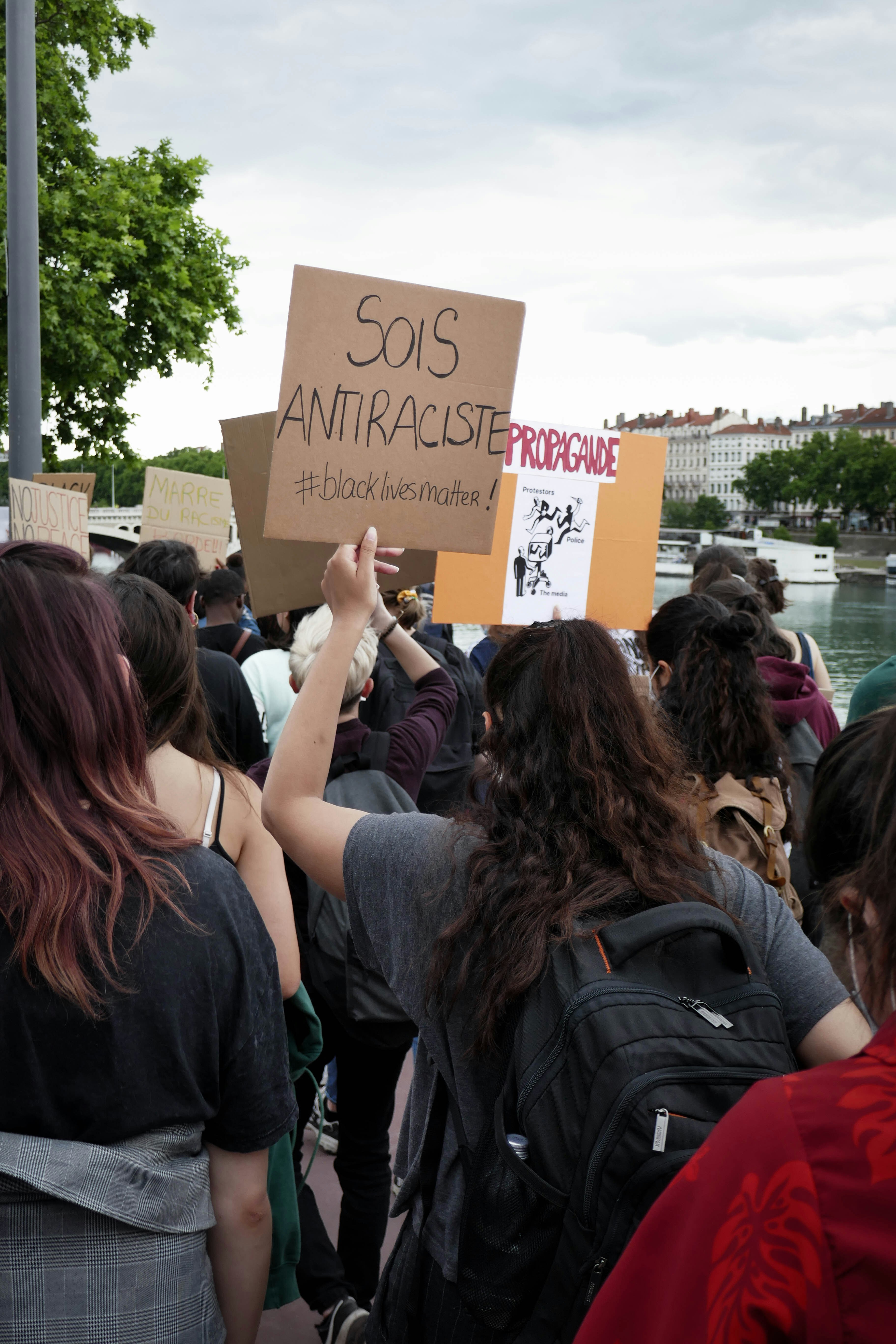 people holding brown and black printed paper during daytime