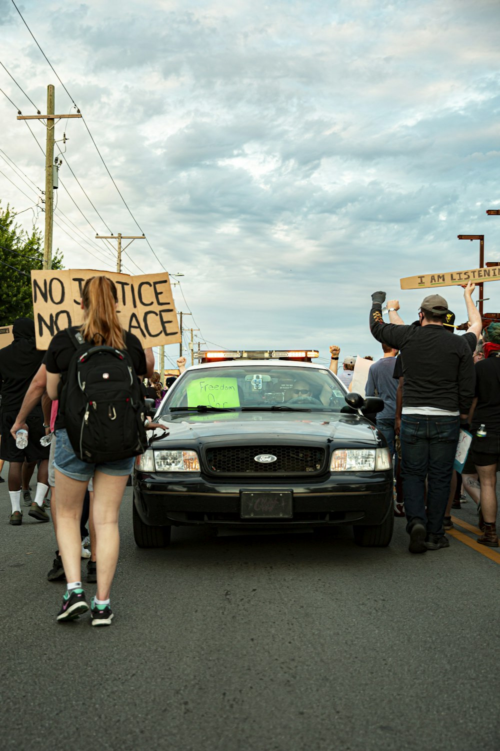 people standing beside black car during daytime