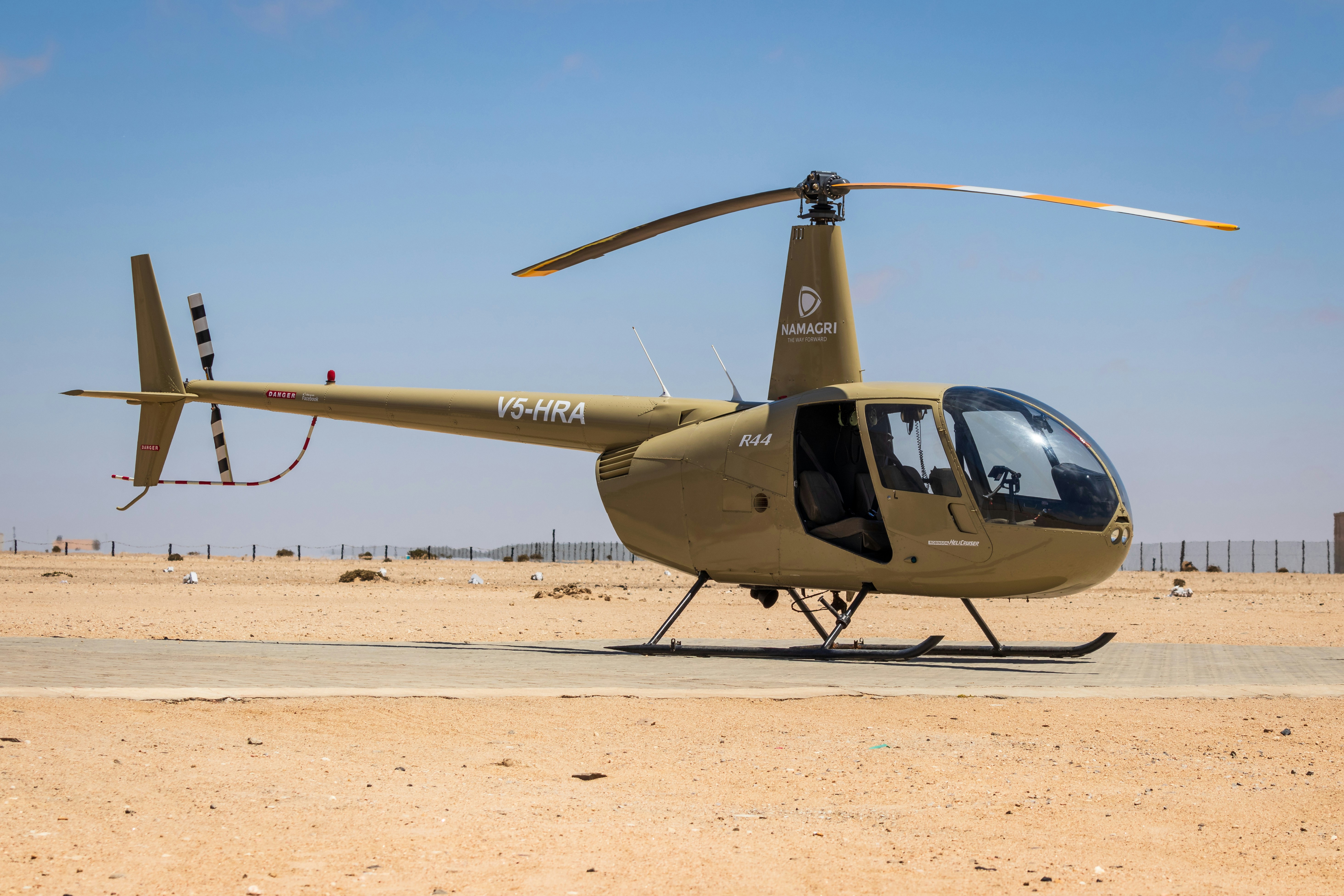 black and yellow helicopter on brown sand during daytime photo Free
