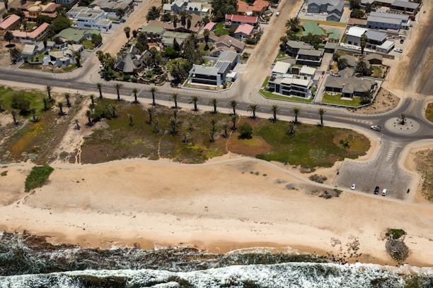 Aerial view of a coastal lot development with palm trees and nearby beach access.