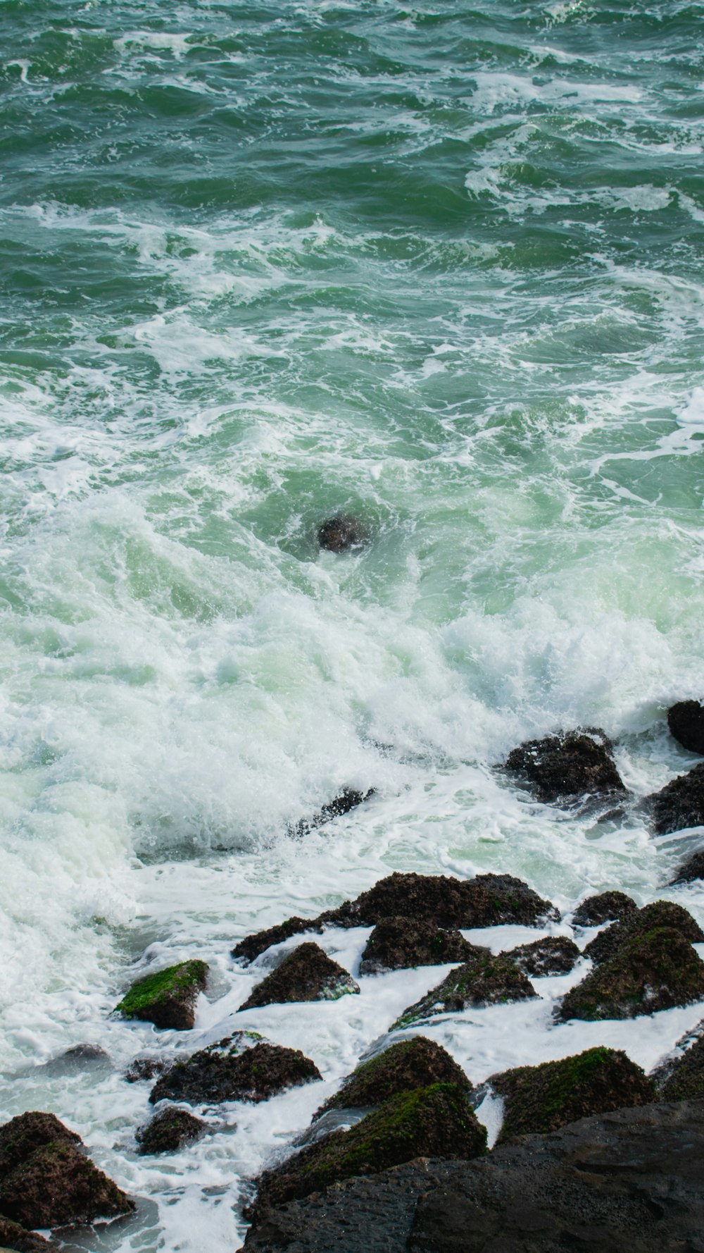 ocean waves crashing on rocks during daytime