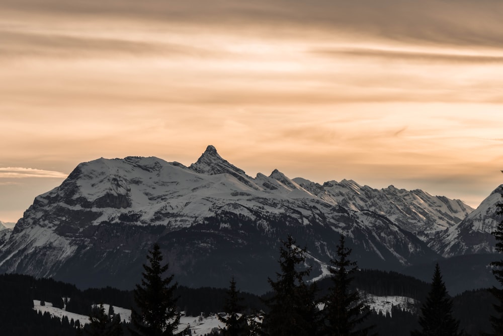 snow covered mountain during sunset