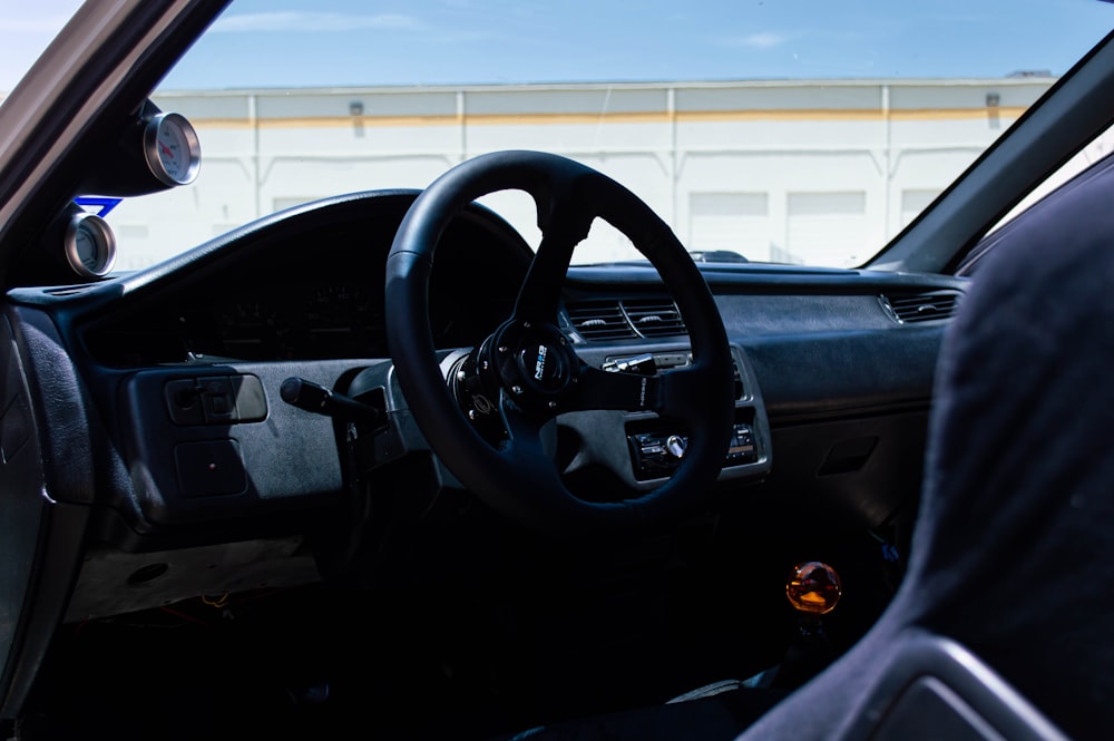 black car steering wheel during daytime