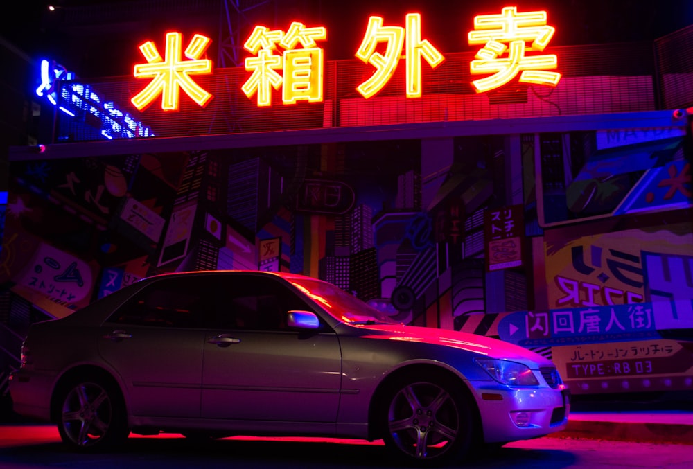 purple sedan parked beside store during night time