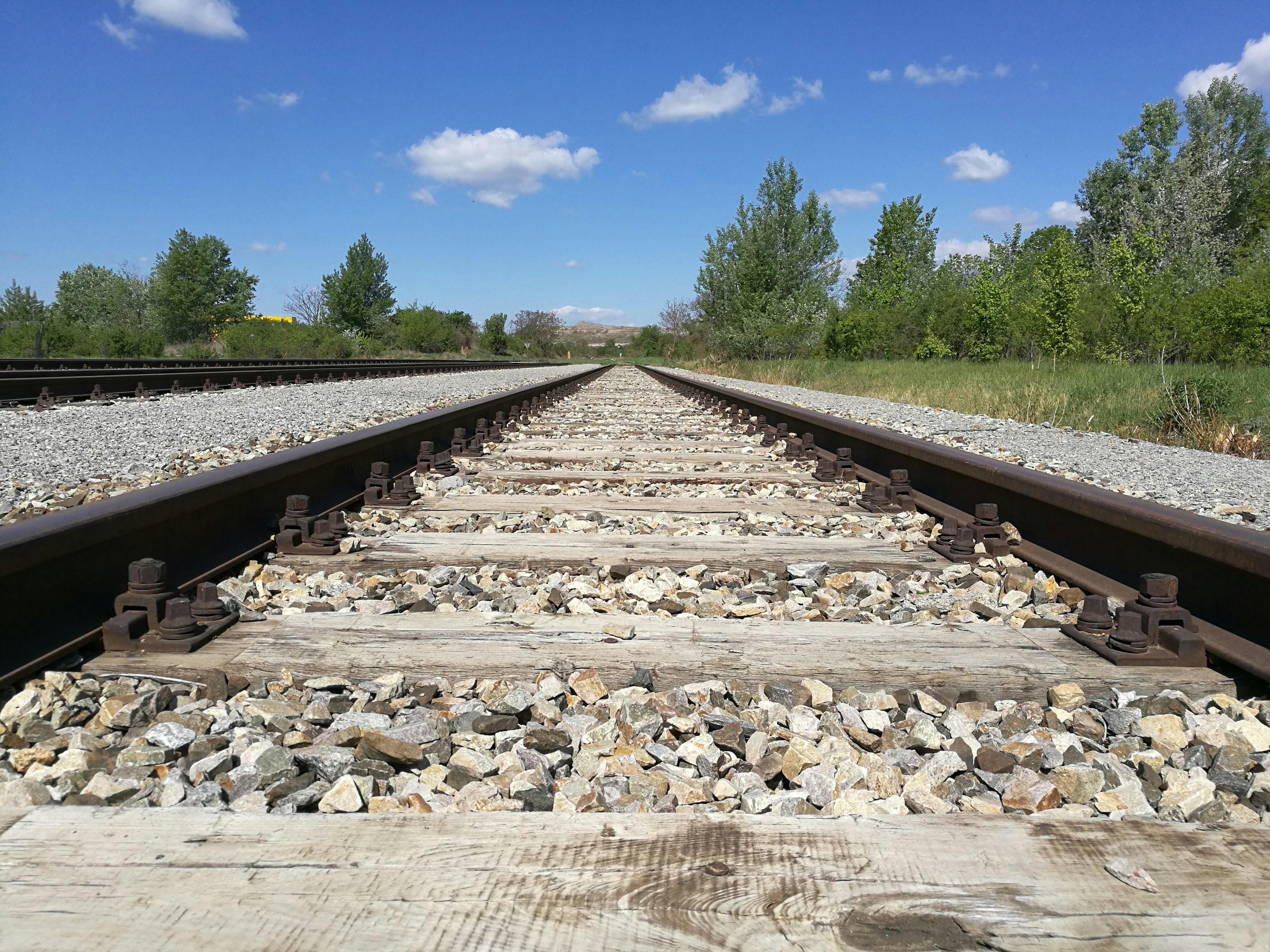 gray and black train rail under blue sky during daytime