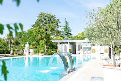 white outdoor fountain near green trees during daytime
