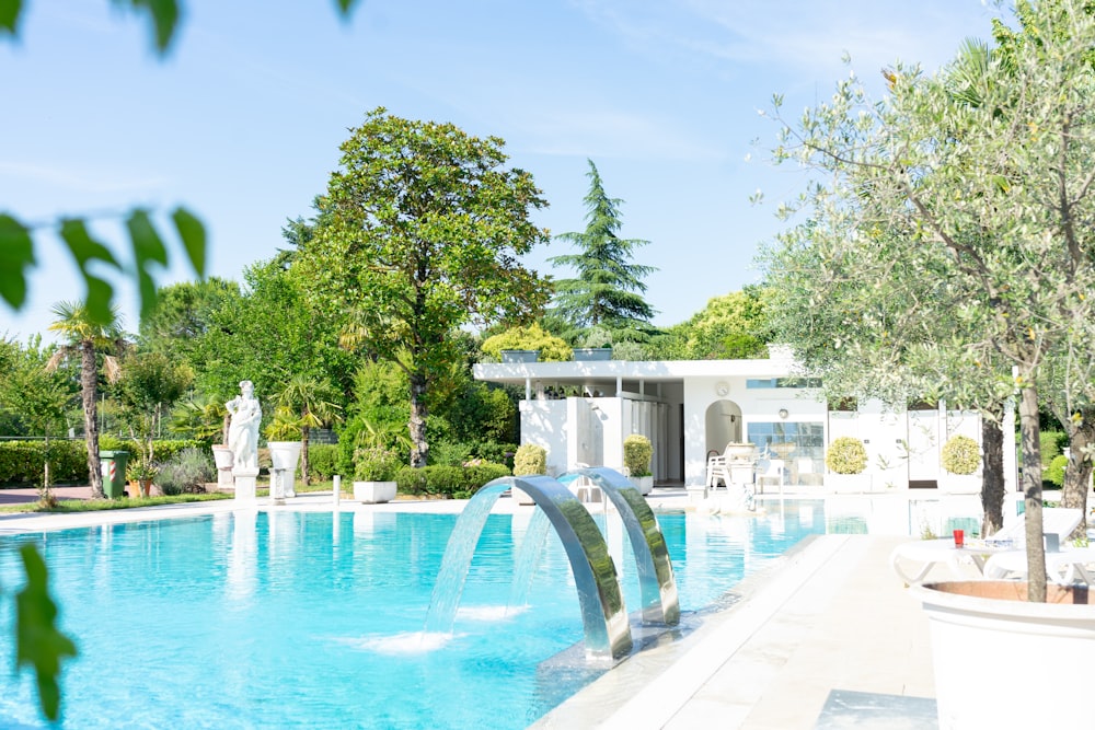 white outdoor fountain near green trees during daytime