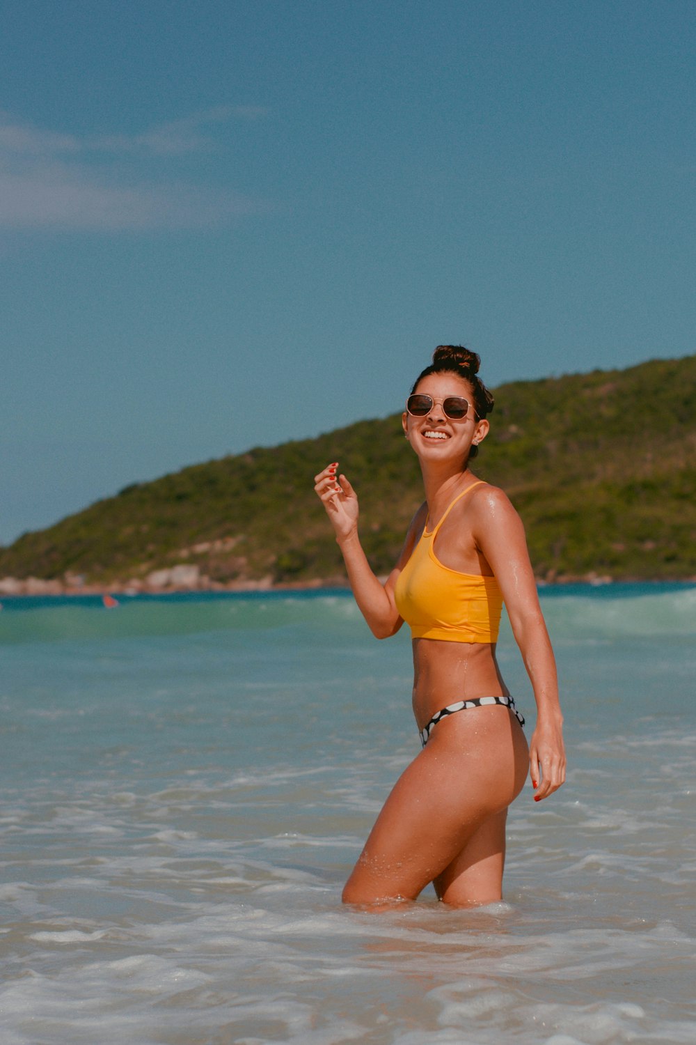woman in yellow bikini standing on beach during daytime