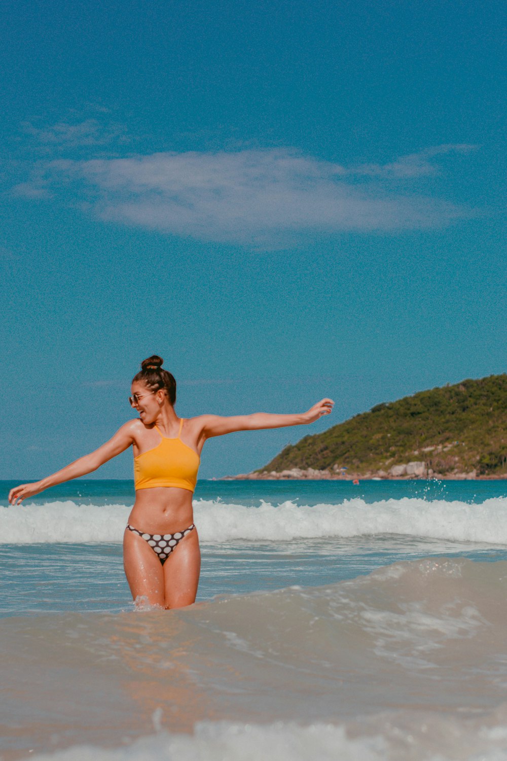 woman in pink bikini standing on beach during daytime