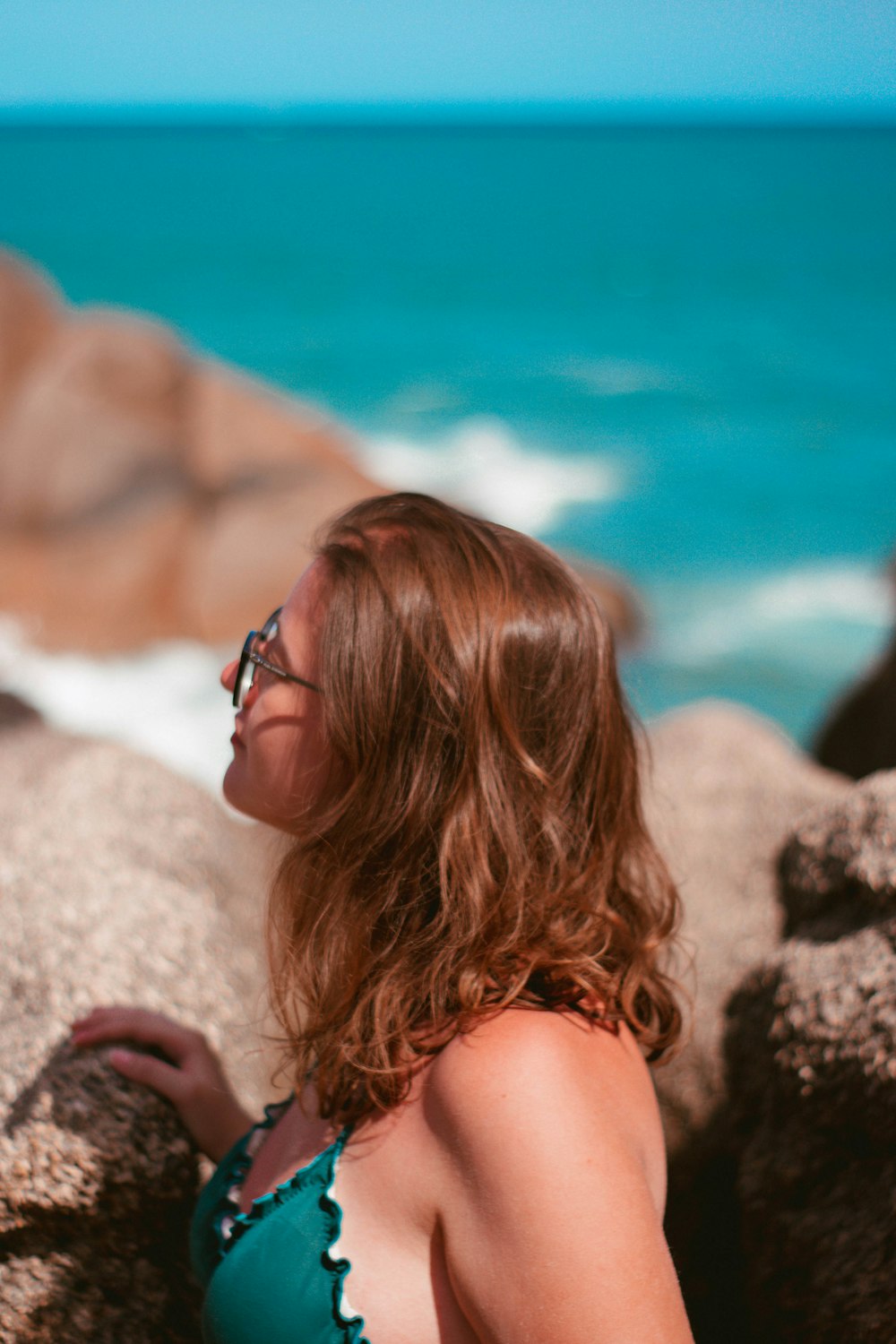 woman in black framed sunglasses on white rock during daytime