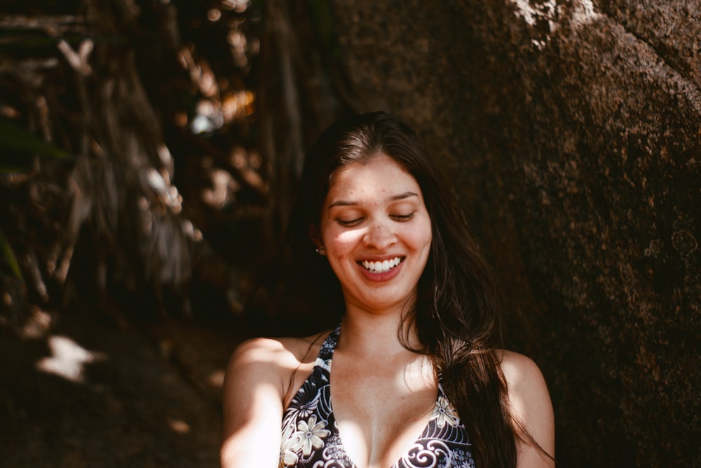 smiling woman in white and black floral tank top