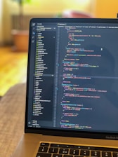 a laptop computer sitting on top of a wooden table