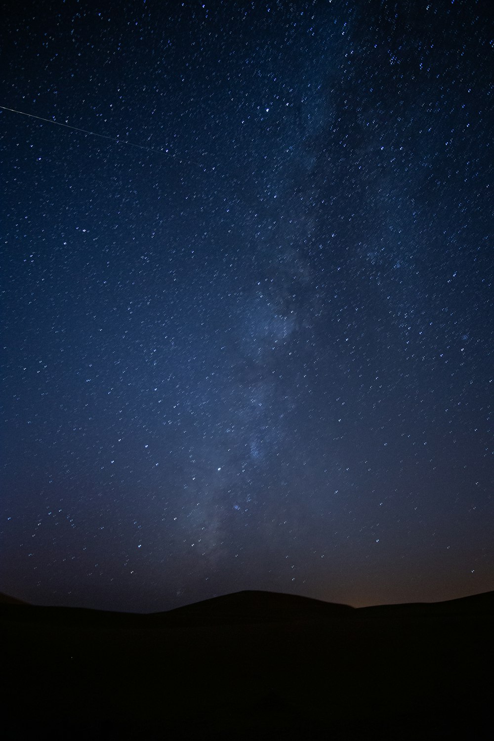 silhouette of mountain under starry night